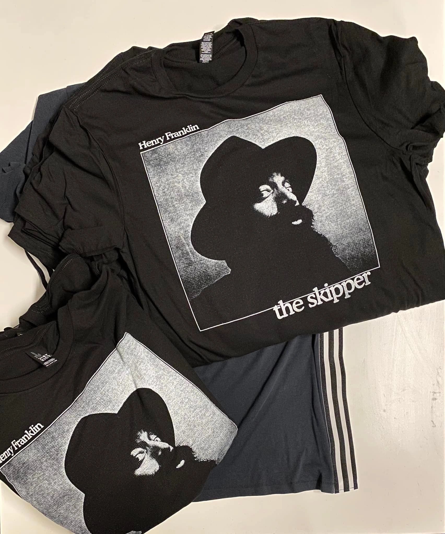 Black garments feature The Stylistics name beneath a monochrome portrait graphic. The image-led design fills a large print area.