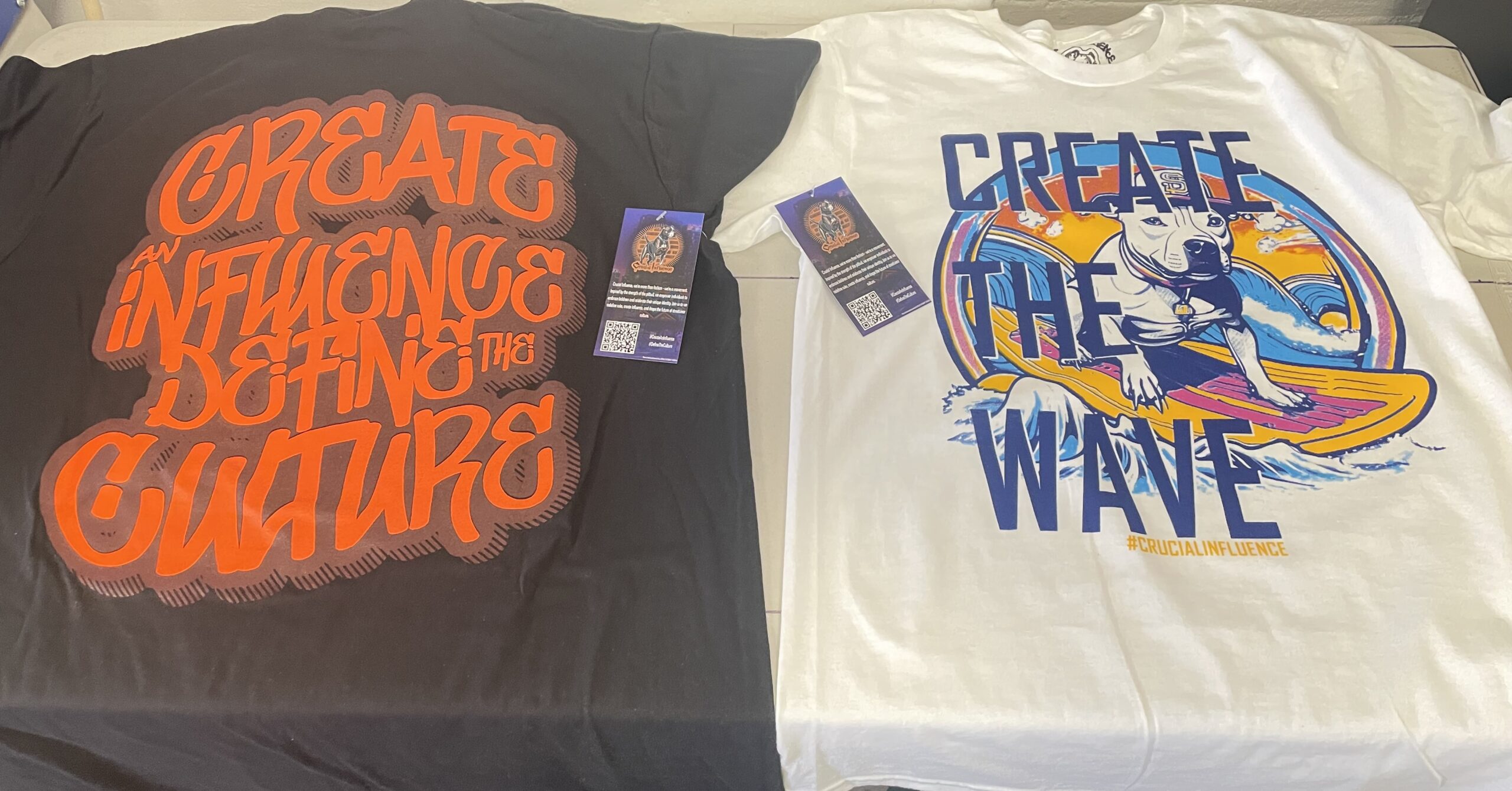 Dark and light tees use different graphic treatments around “Create” and “Wave” lettering, pairing expressive typography with illustrated detail.