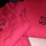 A close view of red garments with dark printed details. The surviving thumbnail is too small to confidently identify the full design.